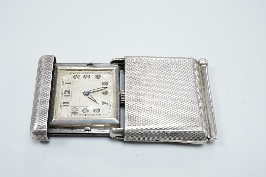 An early to mid 20th century engine turned 935 standard white metal combination travelling watch/pencil holder and notepad section, with Arabic dial, 42mm.